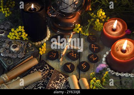 Mystic still life with runes, tarot cards and witchy ritual objects on old altar table. Occult, esoteric, wicca, Halloween and gothic concept. Stock Photo