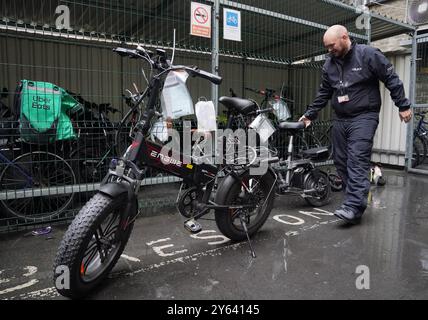 Sergeant Chris Hook handles confiscated illegally modified ebikes at Bishopsgate Police Station in London. Police seizures of illegally modified electric bikes (e-bikes) soared in the past year amid concerns their speed and weight present a lethal threat to pedestrians, according to Freedom of Information (FoI) figures obtained by the PA news agency. Forces across the UK confiscated 937 e-bikes in the year to August 11. Picture date: Thursday September 12, 2024. Stock Photo