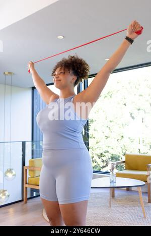 Health conscious woman exercising with resistance band at fitness studio. Female in sportswear doing arms stretching workout with resistance band Stock Photo Alamy