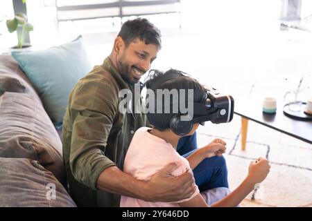 indian father and son using VR headset, bonding and experiencing virtual reality together Stock Photo
