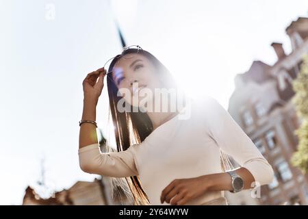 Beautiful and successful. Attractive young woman looking away and smiling while standing outdoors Stock Photo