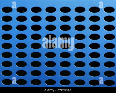 Close-up of a blue bench made of perforated metal in the city area. The full-frame texture shot is ideal as a background or design element. Stock Photo