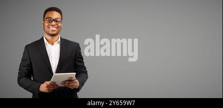 Smiling afro man standing with tablet at studio Stock Photo