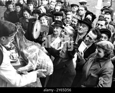 ' Rudolph ' is off the ration . - - Only thing wrong with this picture taken at Smithfield Market , London , is the ration book held by the woman in the centre . For the meat drawing a huge crowd to the counter is reindeer meat - unrationed . Not ' Rudolph the Red Nosed Reindeer ' , the meat is nevertheless a good addition to the family table now anything but groaning under the current 8 - pence - per - person - per - week ration of carcass meat . - - 14 February 1951 Stock Photo