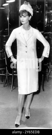 Spring - Summer 1963 fashions of Coco Chanel shown in Paris .  Here a model wears a two-piece afternoon tailored ,  straight line apron skirt trimmed with square buttons . In white woolen 29th January 1963 Stock Photo