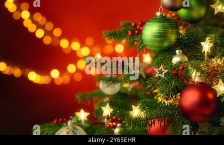 Festive happy Christmas scene with the closeup of a nicely decorated fir tree and red illuminated background with hanging blurred lights Stock Photo