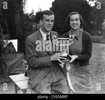 Mixed foursomes golf match at the Worplesdon Golf Club .  Mr John Craddock Hartopp and his sister , Miss Gwen Craddock Hartopp , who defeated Miss Jean Hamilton and Mr Stuart Forsyth , receive their trophy . 1935 Stock Photo