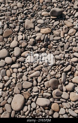 Detailed close-up of a myriad of smoothly rounded pebble stones, capturing the natural texture and varied shapes at Las Negras beach in Cabo de Gata, Stock Photo