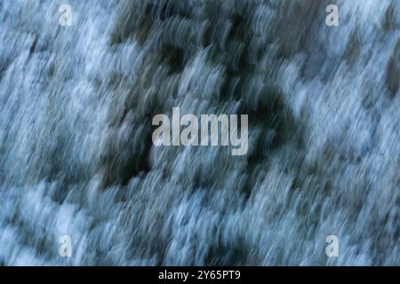 Abstract image capturing a blurred effect of a snow-covered forest in winter The motion blur creates a dynamic and artistic impression of the natural Stock Photo
