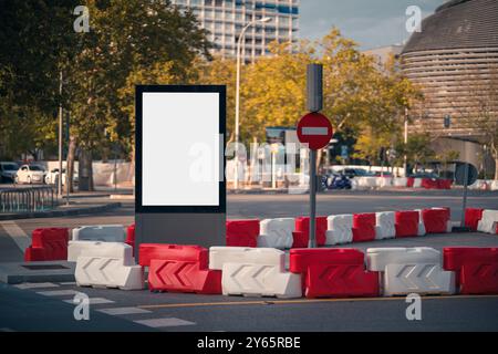 An urban street view in Madrid's AZCA district, with a blank billboard ready for advertising, road signage, and modern buildings in the background. Stock Photo