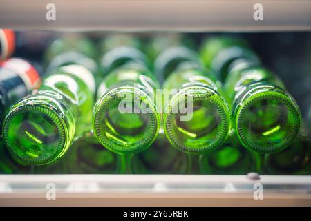 A close-up of green glass bottles stacked with focus on their rims, suggesting recycling or storage theme. Stock Photo