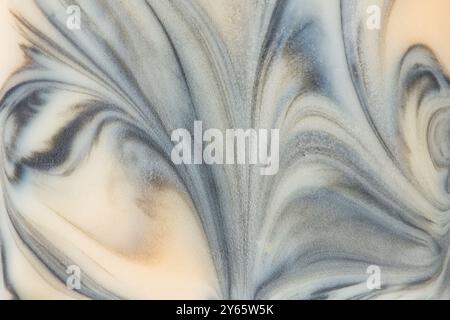 An elegant and high-resolution image capturing the intricate swirls of a creamy marble texture with gray accents, ideal for background use. Stock Photo