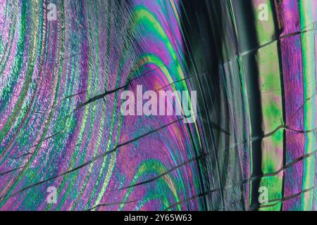 This image features an iridescent holographic pattern with a blend of shimmering colors and textured lines, ideal for creative backgrounds. Stock Photo