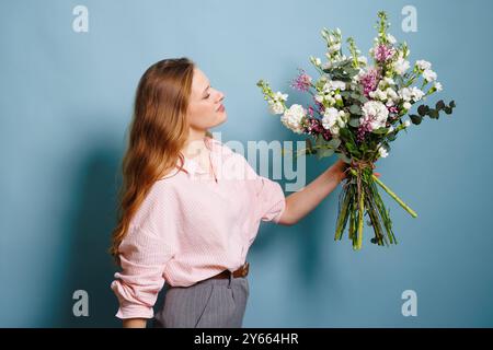 female florist makes a bouquet in a flower shop, spring bouquet Stock Photo
