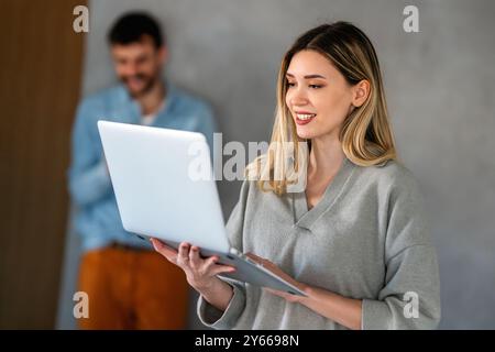 Young female designer, freelancer working in the office. Female using laptop to searching info. Stock Photo
