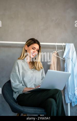 Young female designer, freelancer working in the office. Female using laptop to searching info. Stock Photo