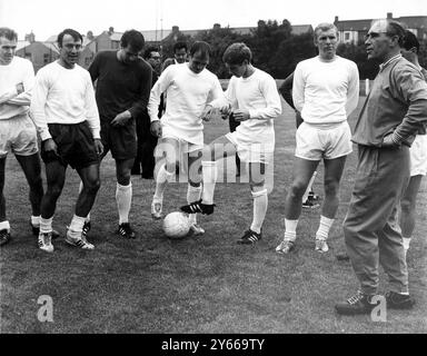 Alf Ramsey talking to members of the England World Cup squad when they trained at the Wembley FC ground in Wembley in readiness for the opening World Cup match against Uruguay. Players in the picture are (left to right) John Connelly, Jimmy Greaves, Martin Peters, Ray Wilson, Alan Ball and Bobby Moore.  10th July 1966 Stock Photo