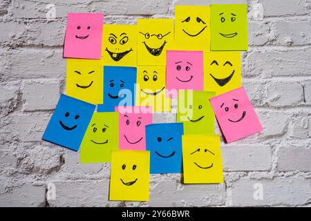 Conceptual image of different post-its of various colors with different smiley faces representing tolerance, diversity and inclusion. Stock Photo