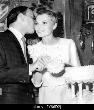 21 Year old Mia Farrow the new Mrs Frank Sinatra gets a kiss from her husband as they cut the wedding cake following their marriage Las Vegas Nevada 20 July 1966 Stock Photo