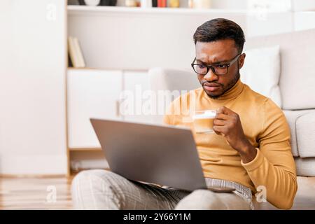 Serious Businessman Using Laptop Having Coffee Working From Home Stock Photo