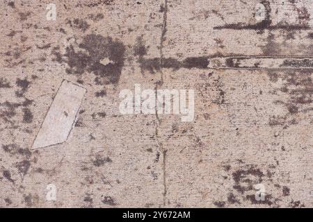 Old and dirty canvas with a patch. Texture of a worn canvas with drips and spots of faded paint, close-up, high resolution. Stock Photo