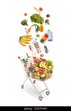 Different food products falling into a shopping cart isolated on white background Stock Photo