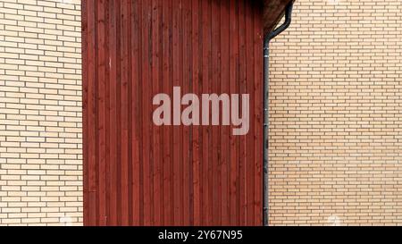 Wooden wall panel is juxtaposed with brick structure in bright daylight illuminating details. Stock Photo