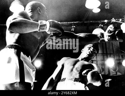 Cassius Clay backs away from a Sonny Liston left hand during the World Heavyweight championship title fight at Miami Beach, Florida when Clay became the new champion. Liston, who claimed that his shoulder was injured in a first round melee, failed to respond to the bell at the start of the 7th round.  25th February 1964. Stock Photo