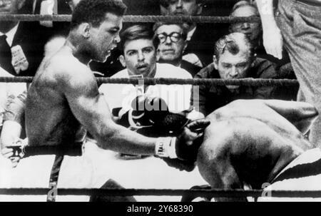 Challenger, Cassius Clay bangs a right to the left shoulder of crouching Sonny Liston, during their world heavy-weight contest at Miami Beach, Florida. Clay became the new champion on a TKO, when Liston failed to respond to the bell at the start of the 7th round. 25th February 1964     . Stock Photo