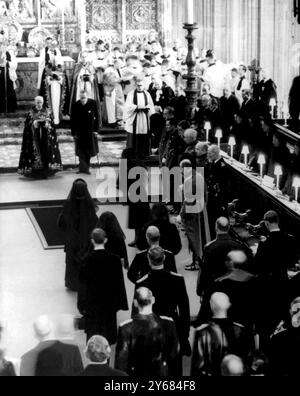 Queen Elizabeth II stands to the right of the Royal Tomb in St George's Chapel, Windsor, and scatters soil on the coffin of King George after it had been lowered into the tomb this afternoon. At the foot of the tomb stands the late King's widow, the Queen Mother.  Behind her Majesty, veiled like the Queen and Queen Mother are Princess Margaret (left) and the Princess Royal.  Behind their Royal Highnesses stand (left to right) the Dukes of Kent, Windsor, Gloucester and Edinburgh.  Behind the Duke of Windsor is his late Majesty's personal Naval Aide-de-Camp, Earl Mountbatten.  At the head of the Stock Photo