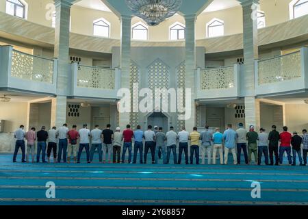 The group of Muslim men praying in Grand mosque of Maykop, Adygea Republic at North Caucasus, Russia. Stock Photo