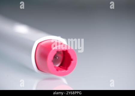 A pen injector with a red tip for biological treatments such as ...