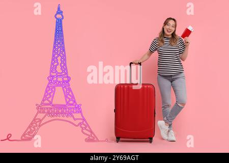 Happy young woman with suitcase, passport and tickets looking at neon illustration of Eiffel Tower on pink background Stock Photo