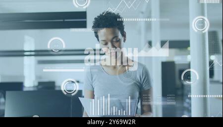 Analyzing documents, businesswoman with data visualization image over office background Stock Photo