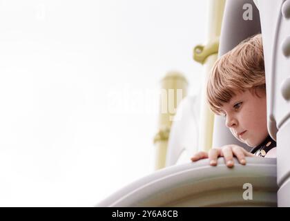 young boy on slide at playground Stock Photo