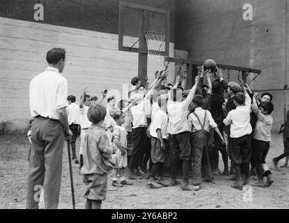 Carnegie playground 5th Ave. N.Y.C., Photograph shows children playing basketball at a playground located at the northeast corner of Fifth Avenue and 91st Street, New York City., 1911 Aug. 11, N.Y.C, Children, Glass negatives, 1 negative: glass; 5 x 7 in. or smaller. Stock Photo