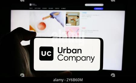 Germany. 21st Sep, 2024. In this photo illustration, a person is holding a cellphone with the logo of Indian home services marketplace company Urban Company in front of webpage. (Credit Image: © Timon Schneider/SOPA Images via ZUMA Press Wire) EDITORIAL USAGE ONLY! Not for Commercial USAGE! Stock Photo