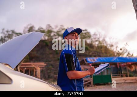 potrait male car technician worker writing inspection result Stock Photo