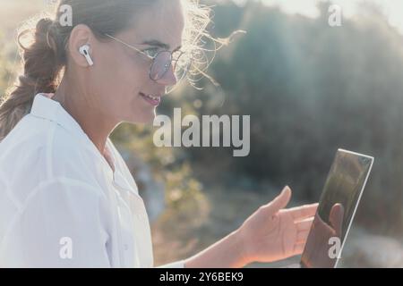 Woman Tablet Outdoors Working Remotely on Laptop in Nature. Stock Photo