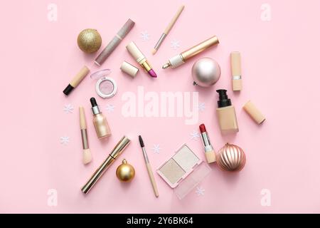 Frame made of makeup products and Christmas decorations on pink background Stock Photo
