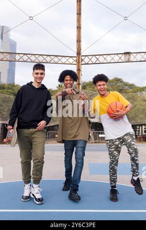 multiracial male teens having fun in sports court Stock Photo