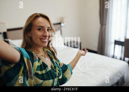 Portrait of Smiling Woman Taking Selfie in Bedroom Stock Photo