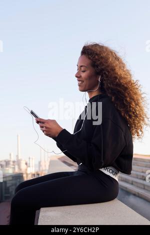 female athlete in earphones texting on cellphone Stock Photo