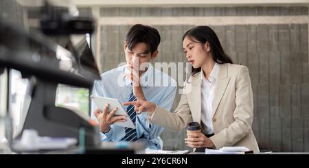 Business Professionals Strategizing Over Digital Tablet in Modern Cafe Environment Stock Photo
