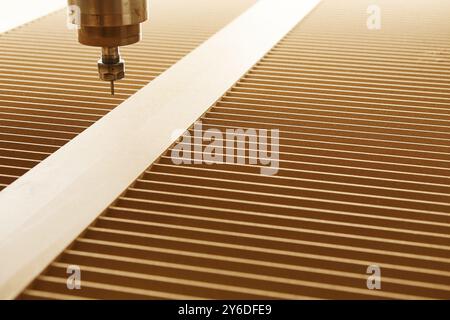 Numerically controlled woodworking machine cuts complex lines on the canvas. Computer numerical control. CNC. Stock Photo