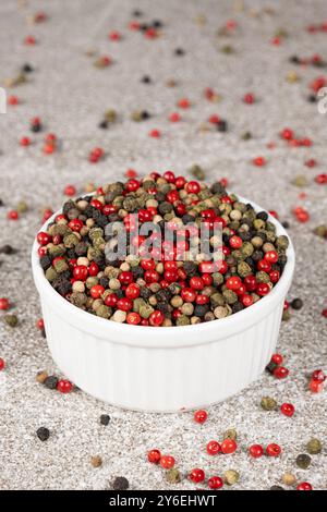 Multicolored peppercorns on a stone gray background. Stock Photo