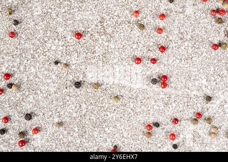 Multicolored peppercorns on a stone gray background. Stock Photo