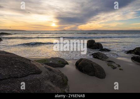 Sunset Over Langebaan; Golden Light, Rolling Waves, and Rugged Coastal Beauty Stock Photo