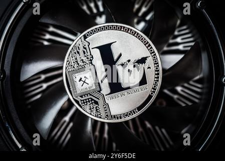 Top view of the litecoin coin lying on spinning blades of ventilator. Litecoin coin on dark background. New virtual money concept Stock Photo