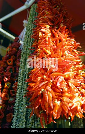 Ingredients for preparing traditional local dishes for sale at a Gaziantep market: chilli peppers, okra and red paprika, dried and strung on a string Stock Photo